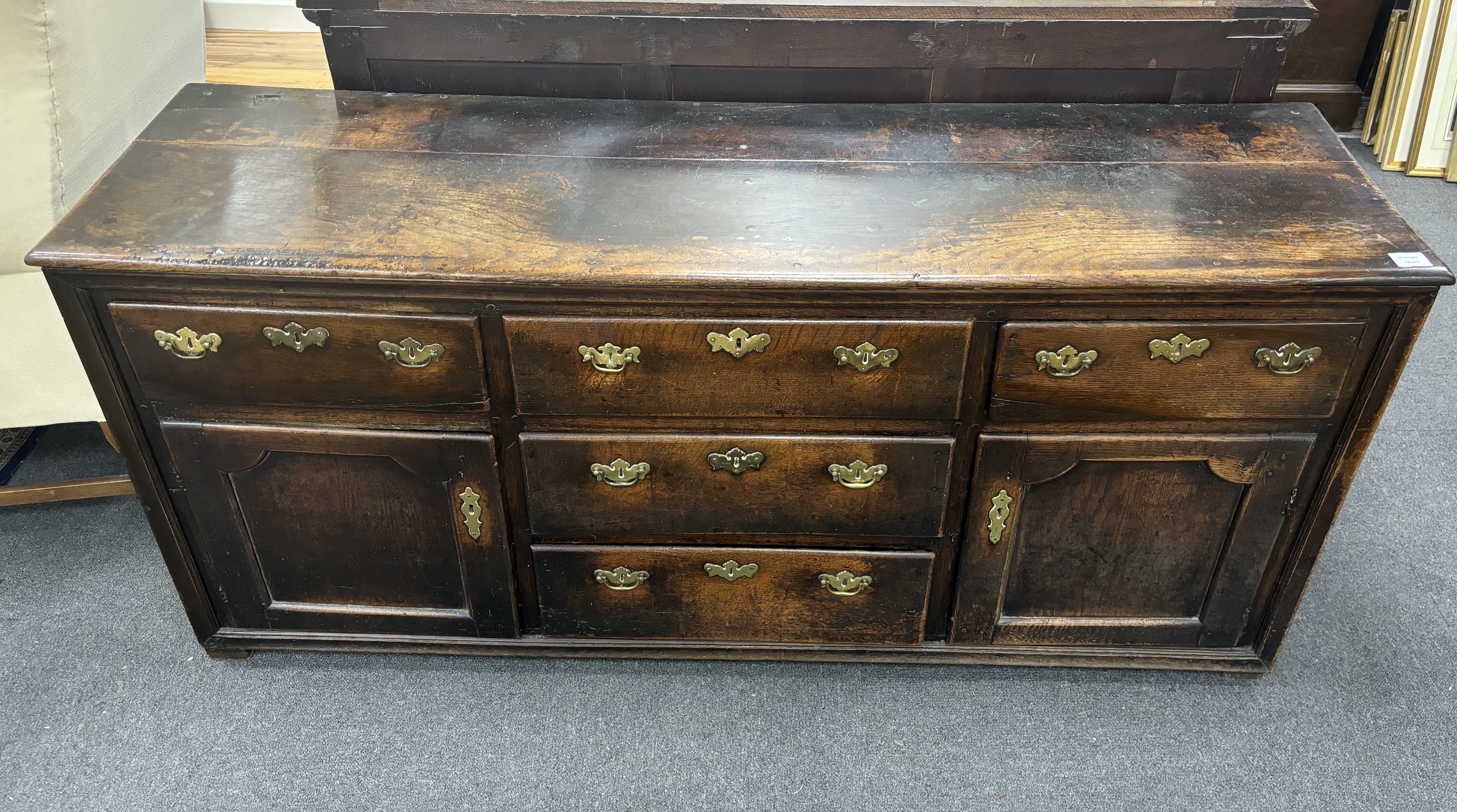 A mid 18th century oak low dresser, fitted five drawers, flanked by panelled doors, width 174cm, depth 48cm, height 79cm